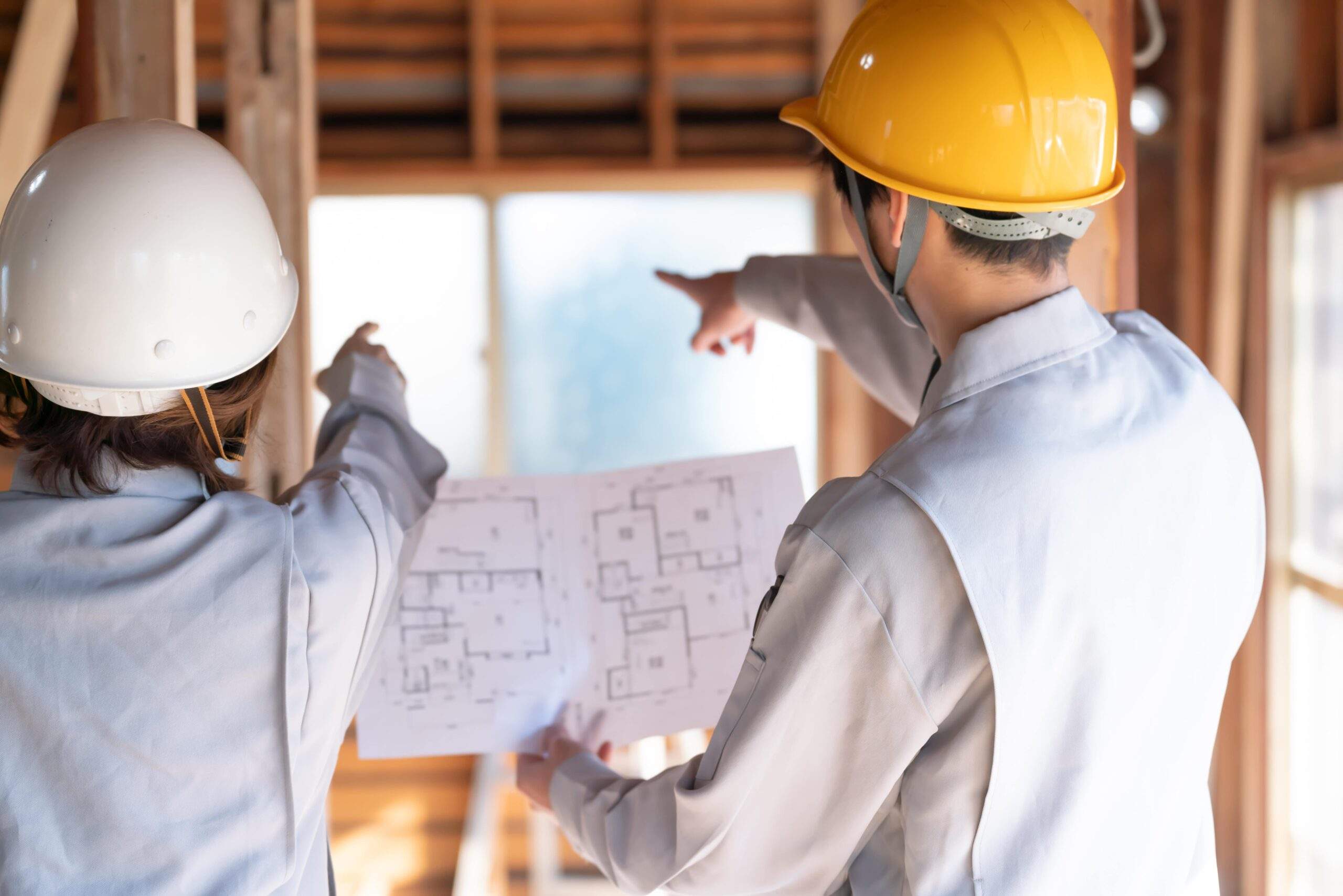 建築現場で図面を確認する作業員
